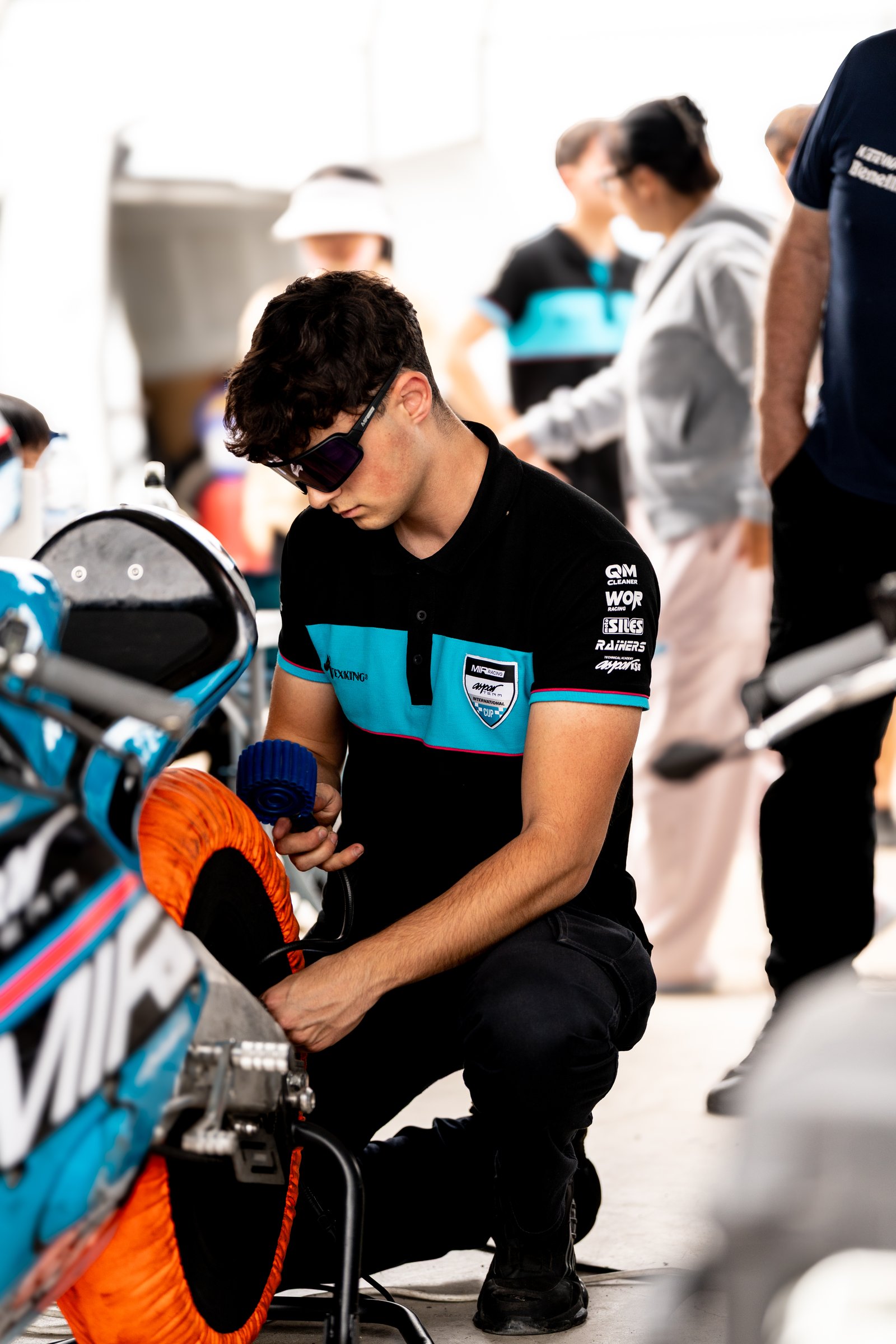 Alumno mecanico revisando neumatico de moto de competicion