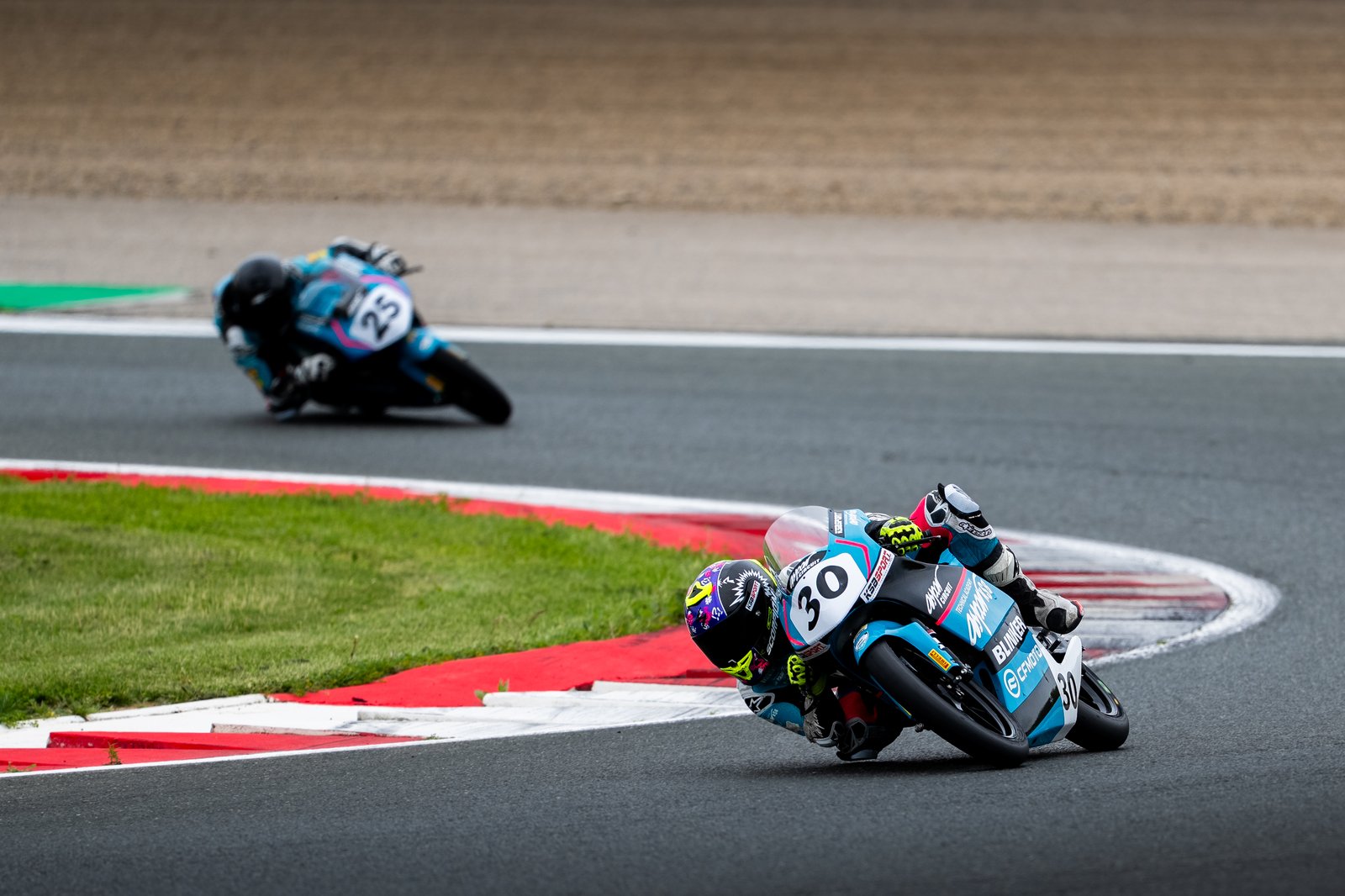 Pilotos Aspar KSB tomando una curva en circuito de competicion